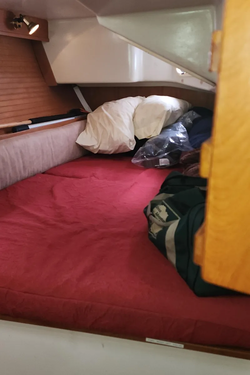 Slide: The Image of Cozy cabin interior of 1995 Catalina 42 MkII sailboat with red bedding and storage. - 40