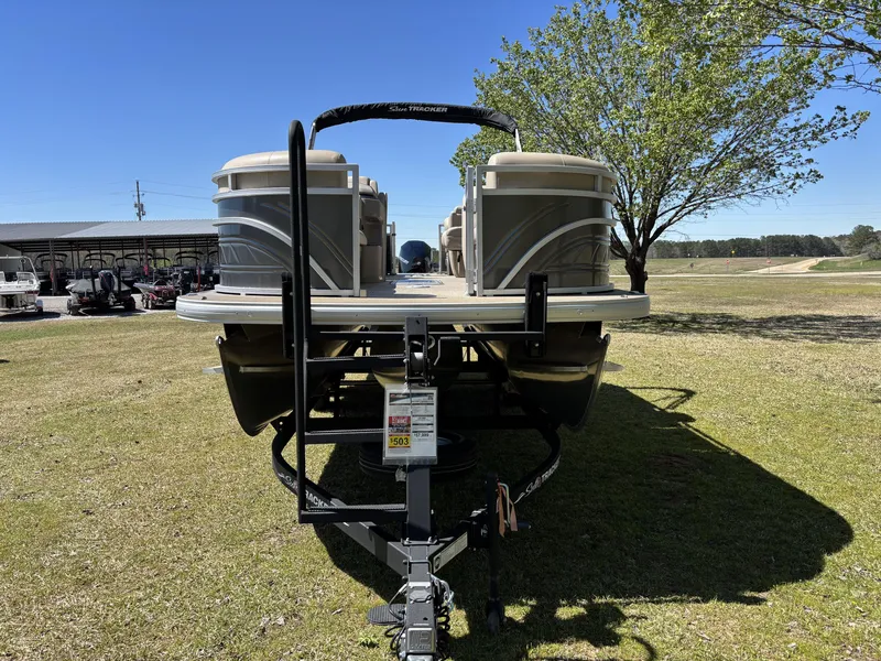 Slide: The Image of 2024 Sun Tracker Party Barge 22 XP3 pontoon boat on trailer, parked on grass. - 4