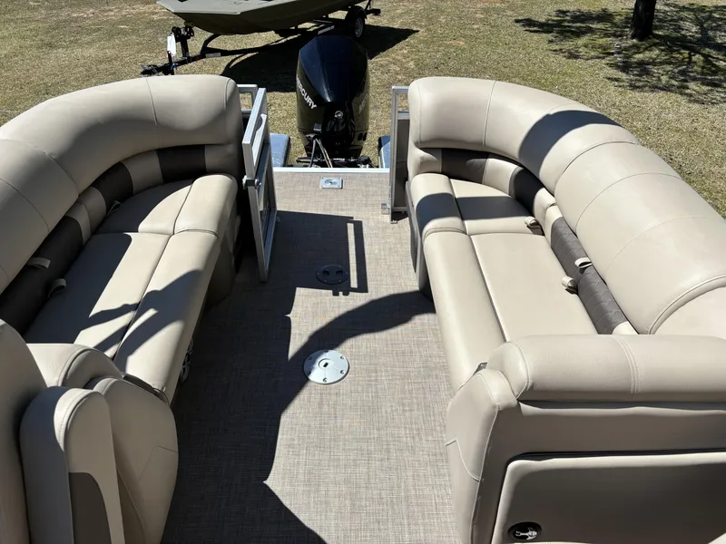 Slide: The Image of 2024 Sun Tracker Party Barge 22 XP3 interior with beige seating and outboard motor. - 6