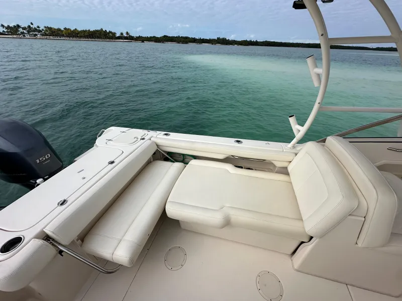 Slide: The Image of 2018 Grady-White Freedom 275 boat interior with seating, near calm waters. - 10