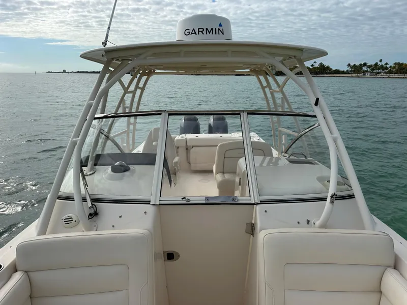 Slide: The Image of 2018 Grady-White Freedom 275 boat on water, featuring Garmin equipment and spacious seating. - 15