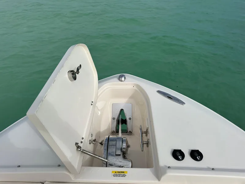 Slide: The Image of 2018 Grady-White Freedom 275 boat anchor compartment open on calm green water. - 16