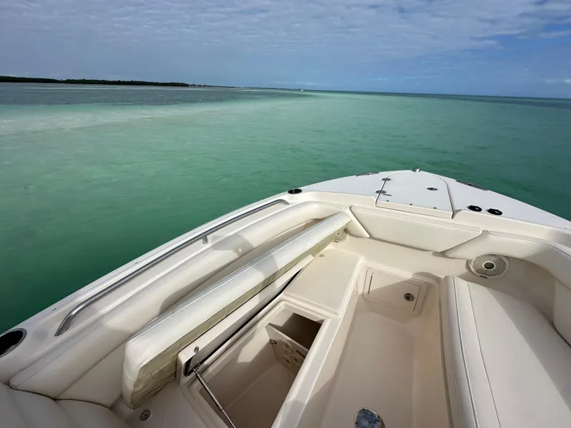 Slide: The Image of 2018 Grady-White Freedom 275 boat on calm turquoise waters under a cloudy sky. - 18