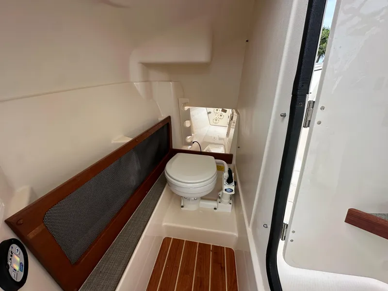 Slide: The Image of 2018 Grady-White Freedom 275 boat interior with compact marine toilet. - 25