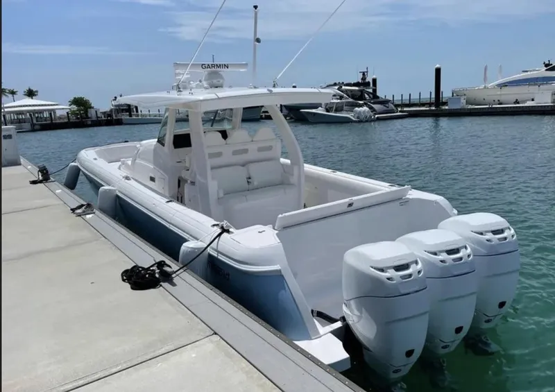 Slide: The Image of 2022 Intrepid 407 Nomad SE boat docked with triple outboard engines. - 4