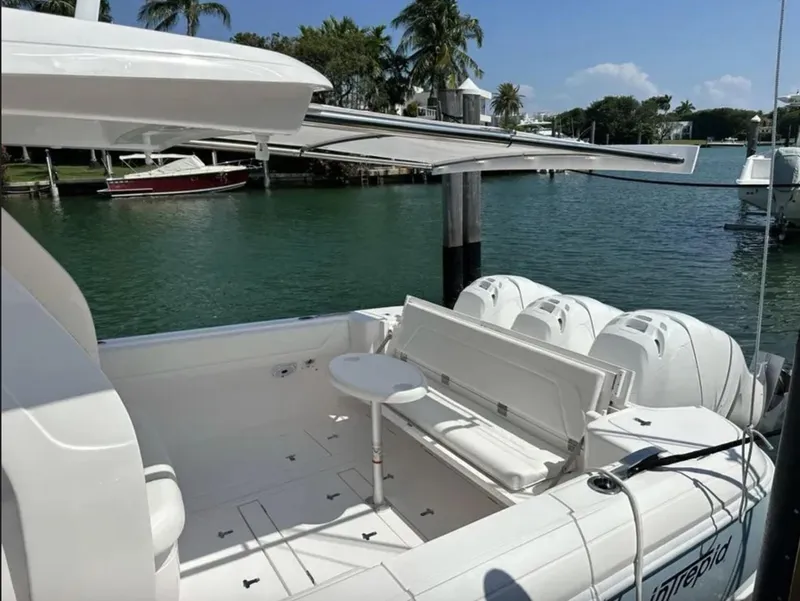 Slide: The Image of 2022 Intrepid 407 Nomad SE boat docked with palm trees in background. - 7