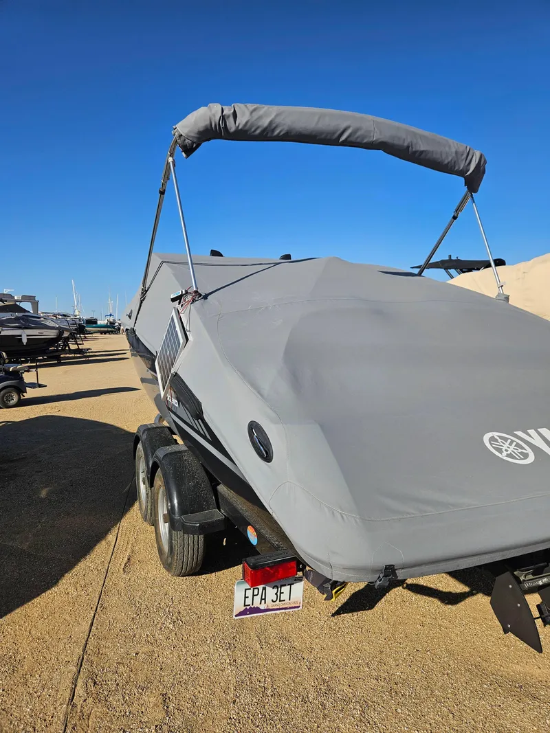 Slide: The Image of 2017 Yamaha SX210 boat covered on trailer under clear blue sky. - 3