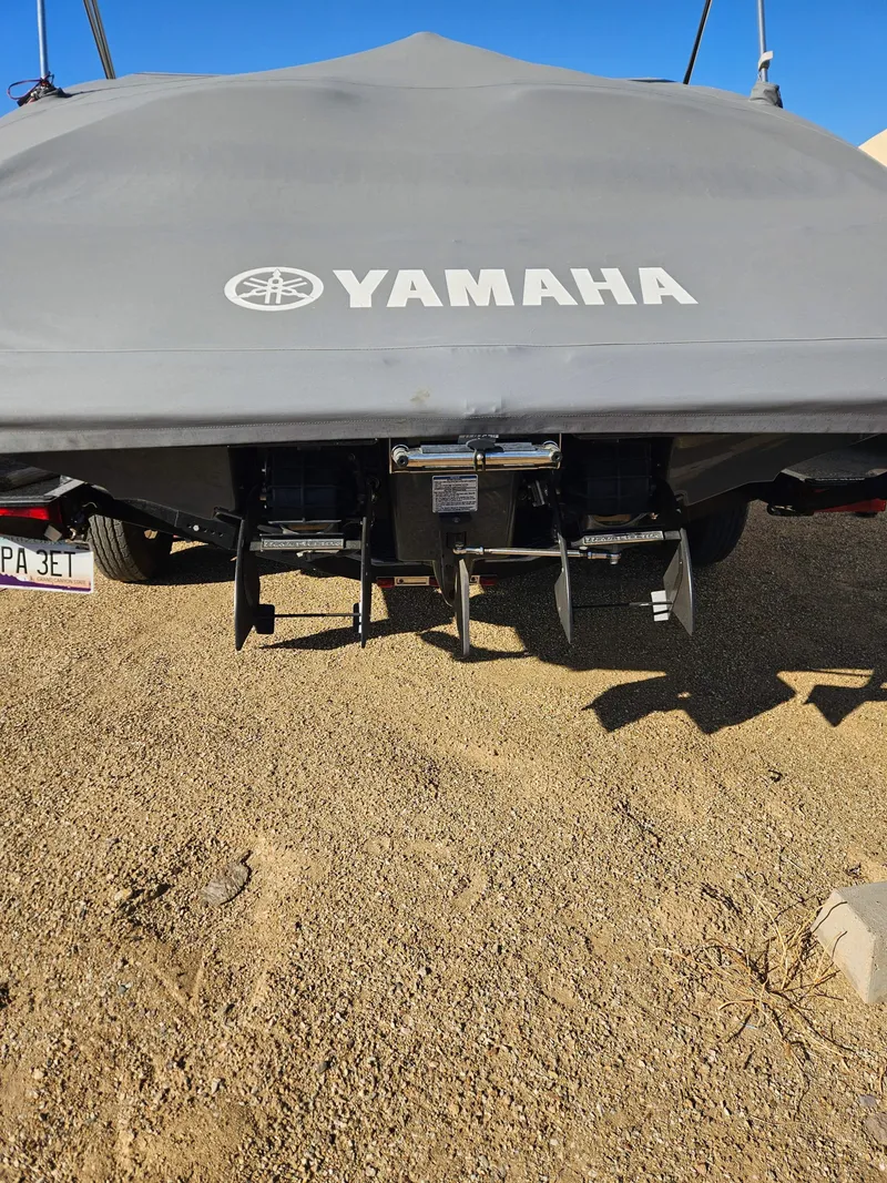 Slide: The Image of 2017 Yamaha SX210 boat with cover, rear view on sandy ground. - 7