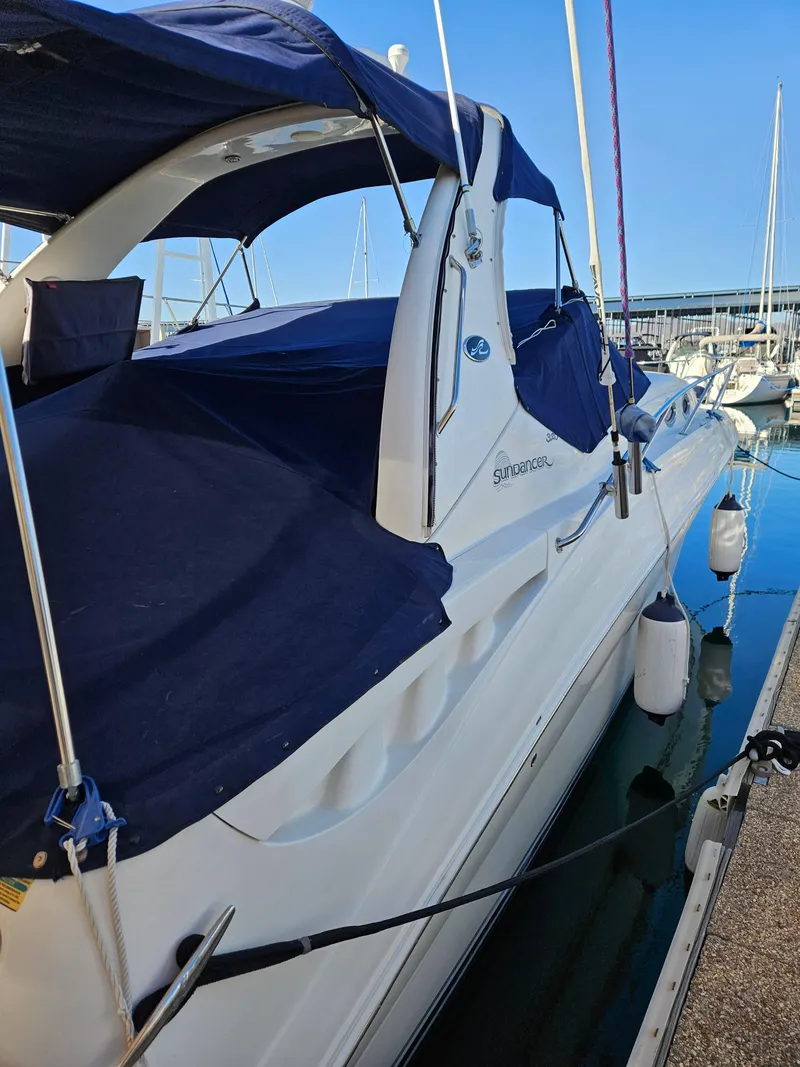 Slide: The Image of 2005 Sea Ray 320 DA boat docked with blue covers in a marina. - 3