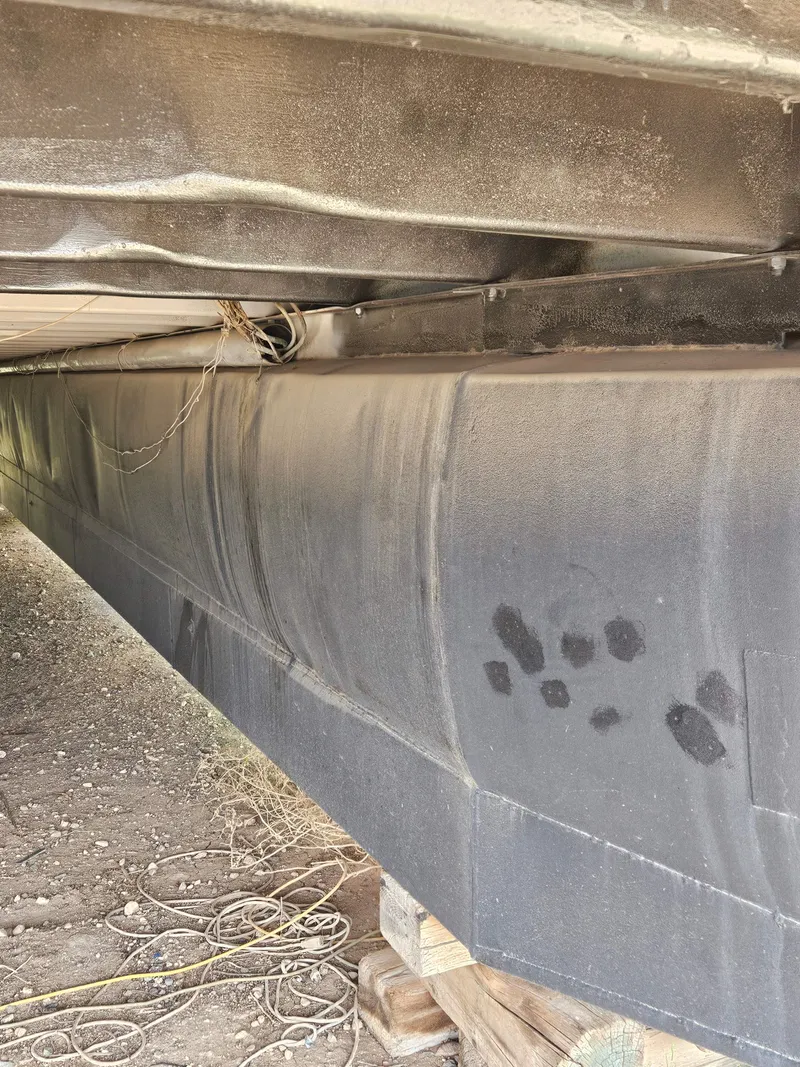 Slide: The Image of Underneath view of a 1990 Skipperliner houseboat hull on dry land. - 16