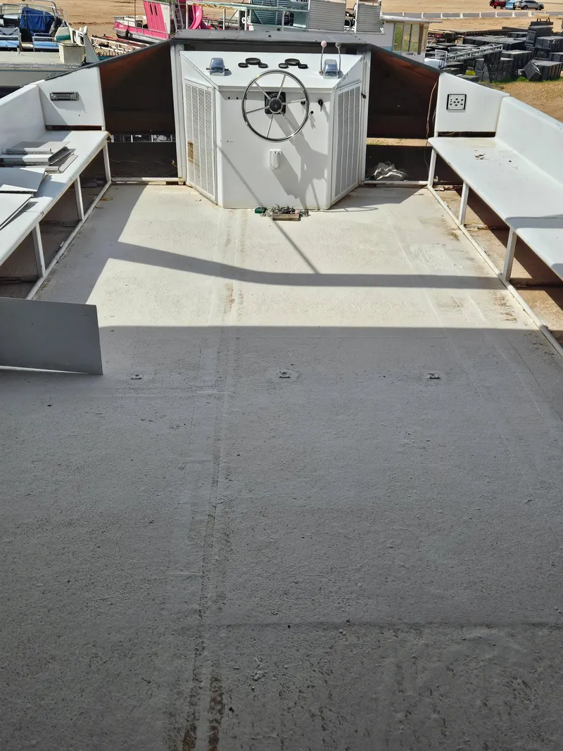 Slide: The Image of 1990 Skipperliner houseboat deck with steering wheel and seating area. - 17