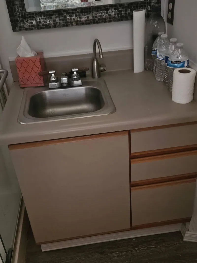 Slide: The Image of Bathroom sink area in a 1990 Skipperliner houseboat, featuring countertop essentials. - 6