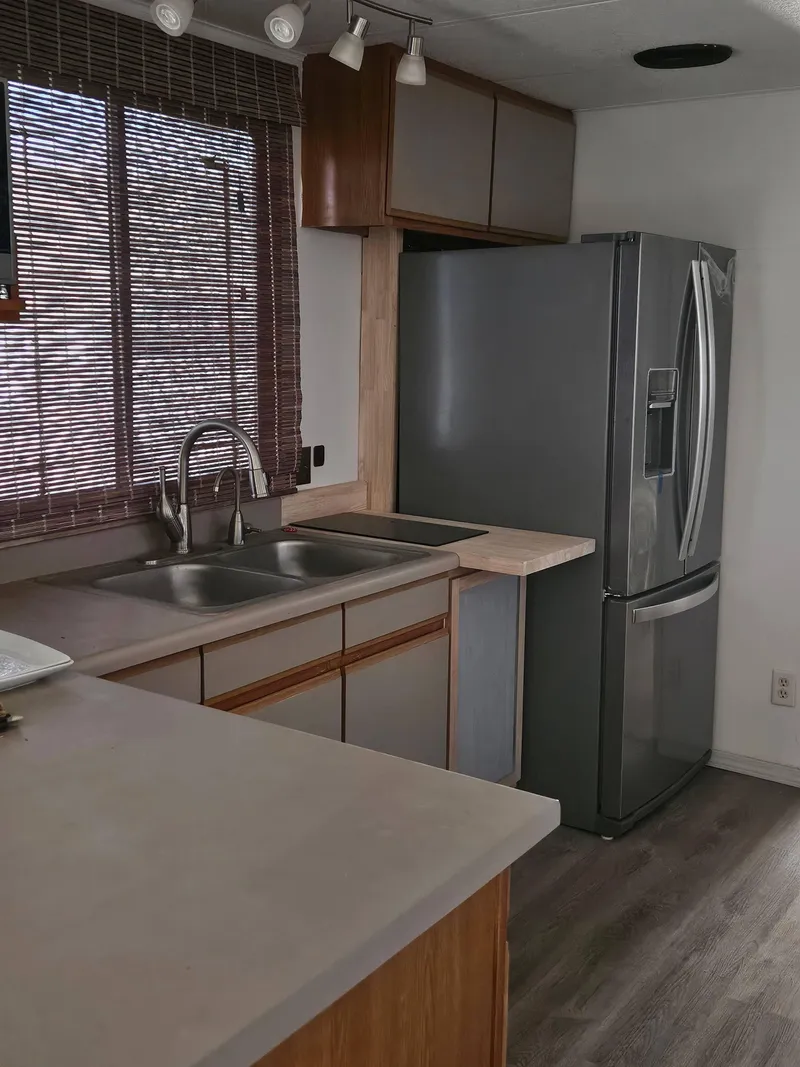 Slide: The Image of 1990 Skipperliner houseboat kitchen with modern appliances and wooden cabinetry. - 8