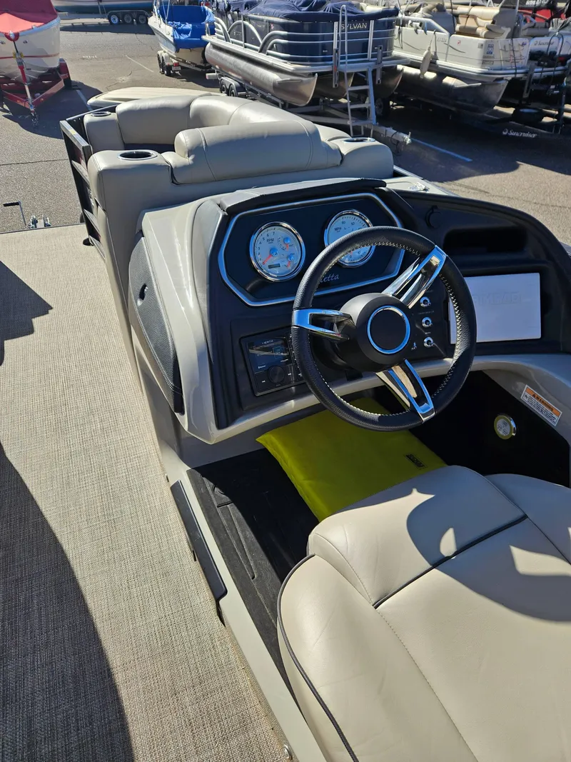 Slide: The Image of 2019 Barletta L21Q Pontoon boat interior with steering wheel and dashboard. - 12