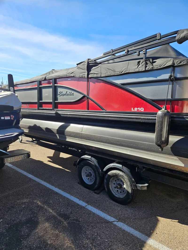 Slide: The Image of 2019 Barletta L21Q Pontoon boat on trailer, red and black design. - 2