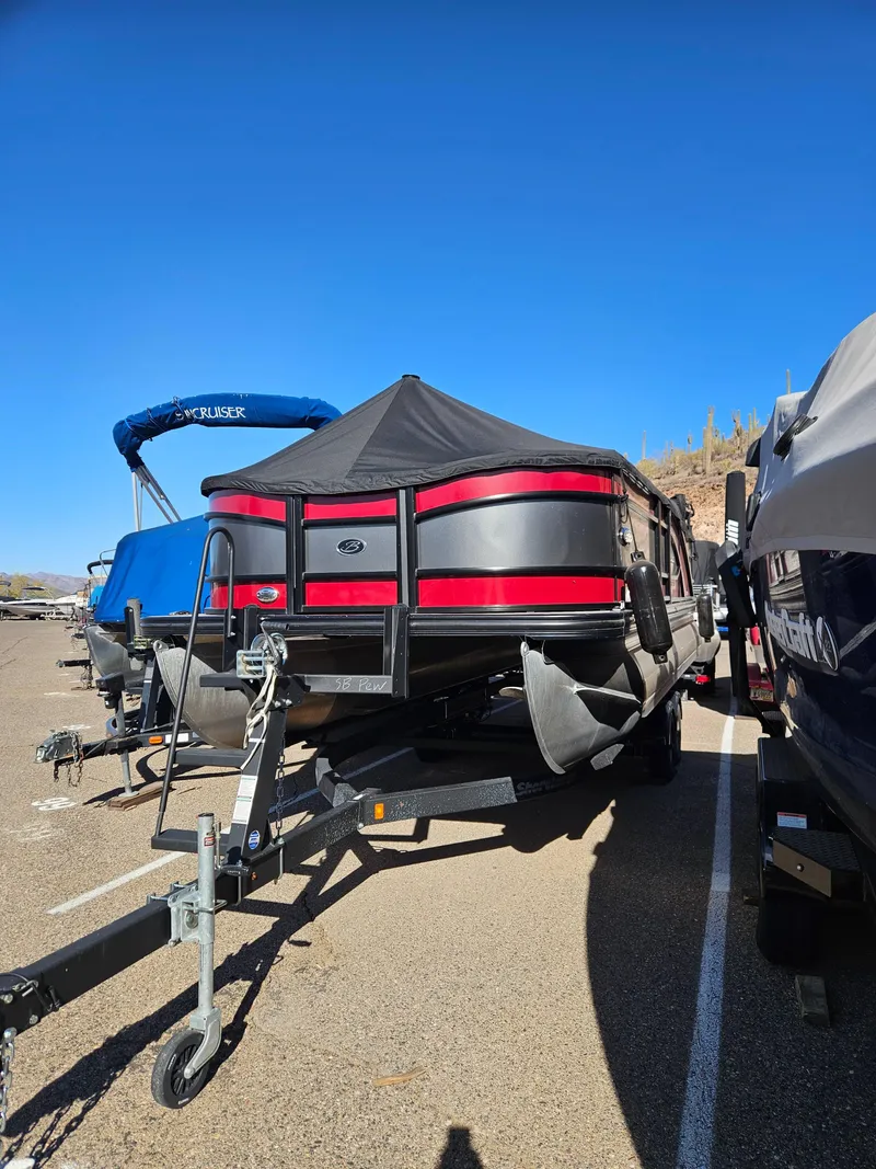 Slide: The Image of 2019 Barletta L21Q Pontoon boat on trailer, parked under clear blue sky. - 3