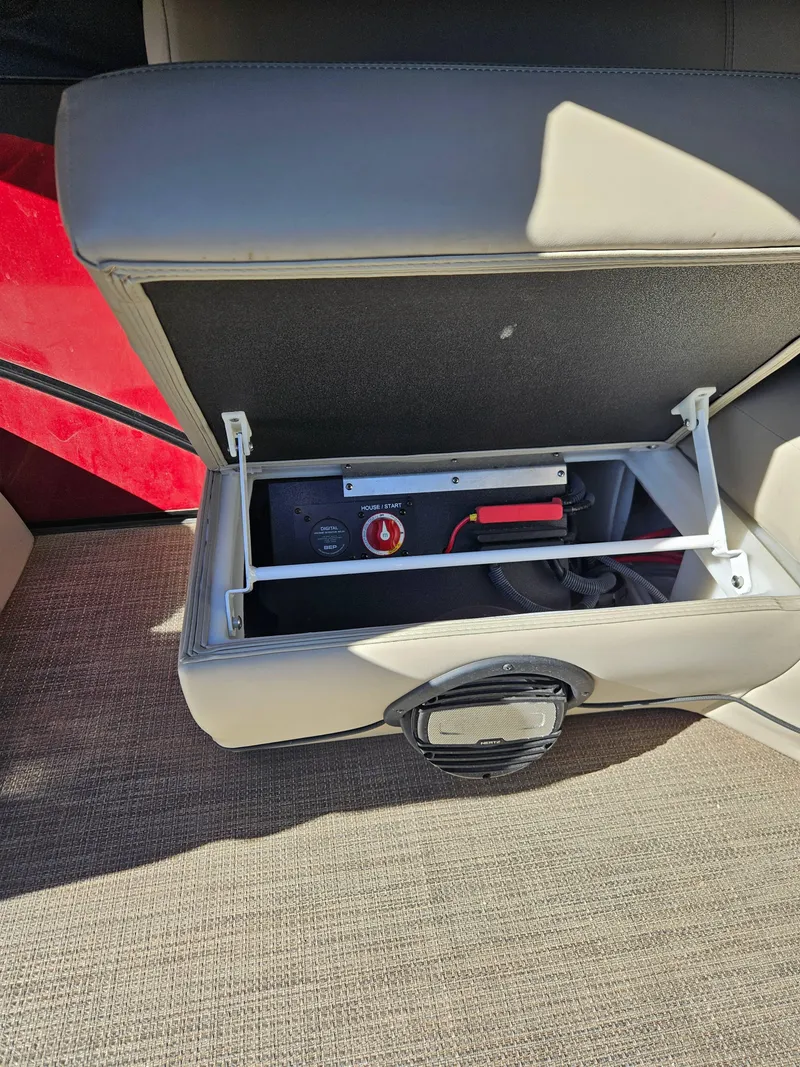 Slide: The Image of Open storage compartment in 2019 Barletta L21Q Pontoon boat, revealing battery switch and wiring. - 6