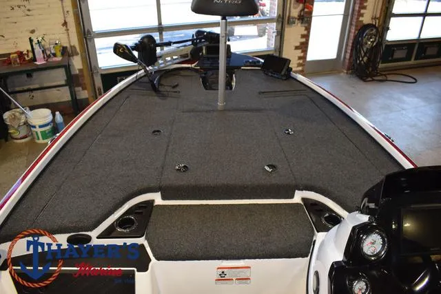 Slide: The Image of 2019 Nitro Z18 boat interior with carpeted deck and control panel in a garage setting. - 11