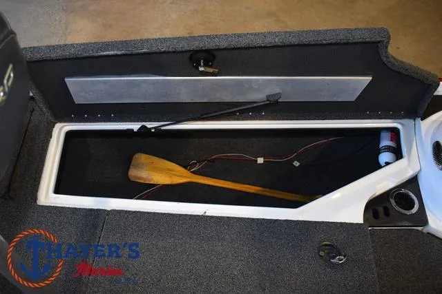 Slide: The Image of Open storage compartment in a 2019 Nitro Z18 boat with a wooden paddle inside. - 12