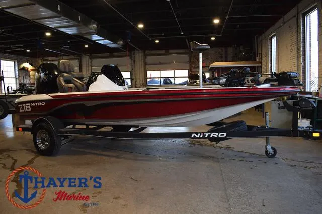 Slide: The Image of 2019 Nitro Z18 boat in showroom, red and white design, displayed on trailer. - 42