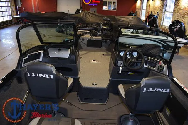 Slide: The Image of 2024 Lund 1775 Impact XS Sport boat interior with dual seats and dashboard controls. - 10
