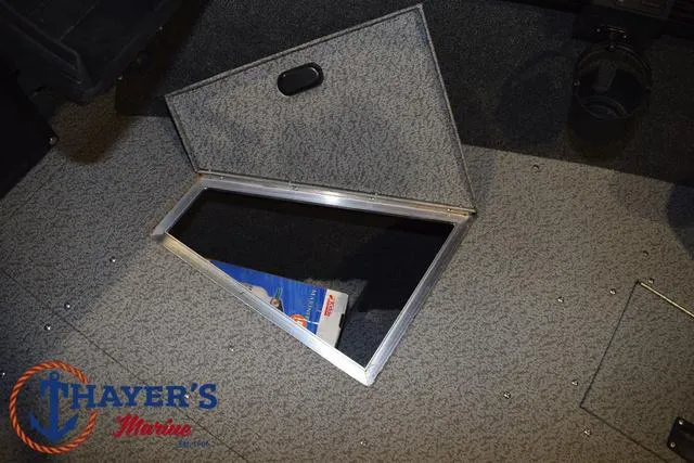 Slide: The Image of 2024 Lund 1775 Impact XS Sport boat storage compartment, open with visible interior. - 19