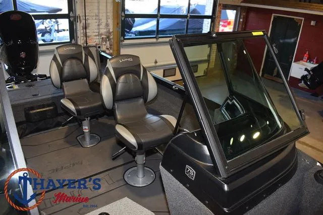 Slide: The Image of 2024 Lund 1775 Impact XS Sport boat interior with two seats and windshield. - 23