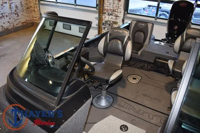 Slide: The Image of 2024 Lund 1775 Impact XS Sport boat interior with seating and steering wheel. - 24