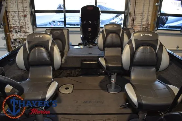 Slide: The Image of 2024 Lund 1775 Impact XS Sport boat interior with four seats and motor. - 25
