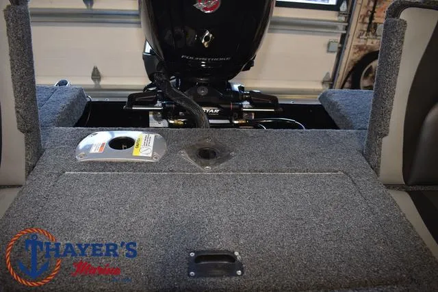 Slide: The Image of 2024 Lund 1775 Impact XS Sport boat interior with motor and storage area. - 30