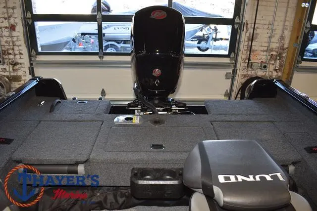 Slide: The Image of 2024 Lund 1775 Impact XS Sport boat interior with motor, seats, and storage compartments. - 31