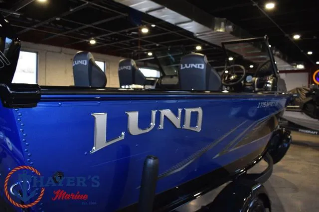 Slide: The Image of 2024 Lund 1775 Impact XS Sport boat in showroom, blue exterior, branded seats. - 35