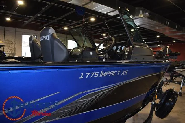 Slide: The Image of 2024 Lund 1775 Impact XS Sport boat, blue exterior, displayed indoors. - 36