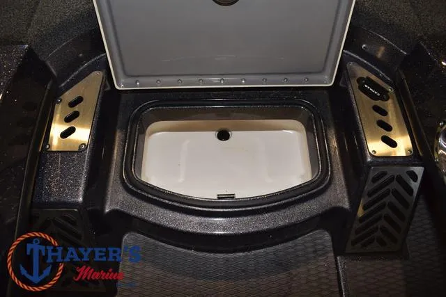 Slide: The Image of 2022 Caymas CX 21 boat storage compartment with open lid, featuring Thayer's Marine logo. - 22