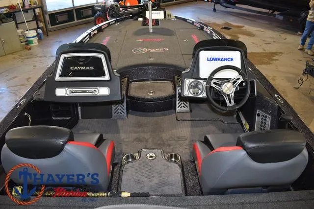 Slide: The Image of 2022 Caymas CX 21 boat interior with dual seats and steering wheel in a showroom. - 34