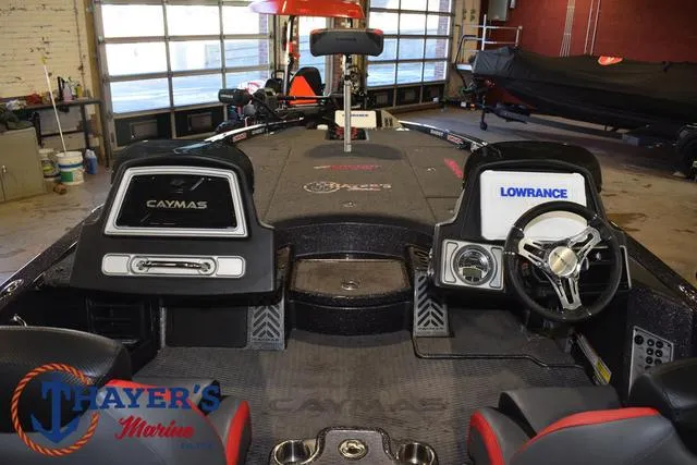 Slide: The Image of 2022 Caymas CX 21 boat interior with steering wheel and dashboard in a garage setting. - 44