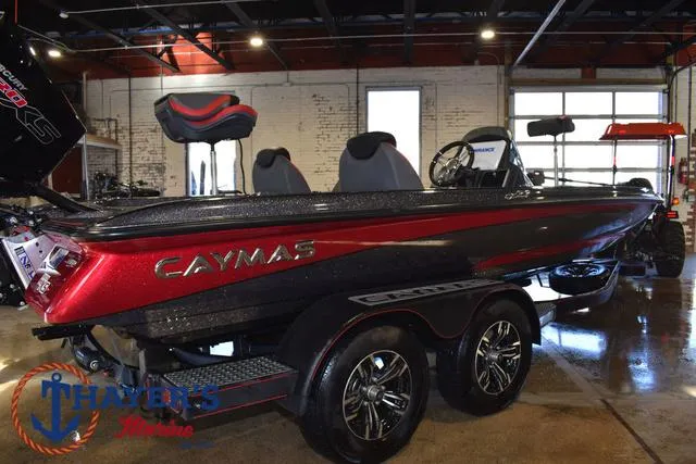 Slide: The Image of 2022 Caymas CX 21 boat in showroom, red and black design, on trailer. - 48