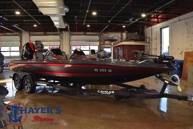 Slide: The Image of 2022 Caymas CX 21 boat in showroom, black and red design, on trailer. - 8