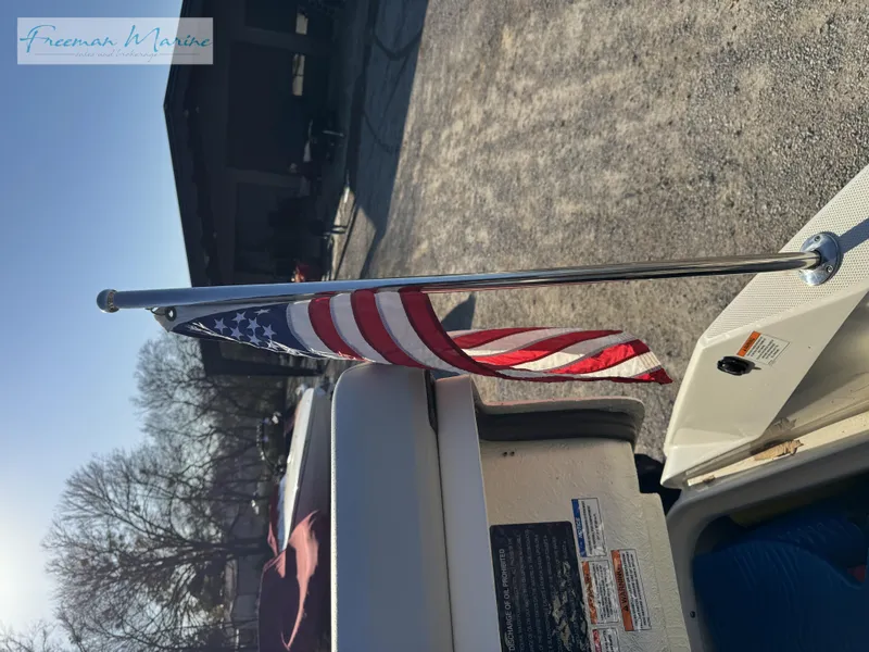 Slide: The Image of 2020 Sea Ray SLX 280 with American flag on stern, parked outdoors. - 36