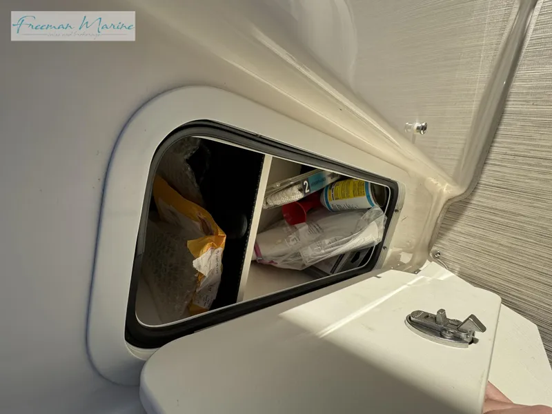 Slide: The Image of Storage compartment on a 2020 Sea Ray SLX 280 boat, containing various items. - 42