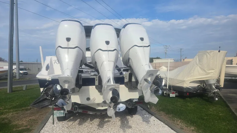 Slide: The Image of 2006 Wellcraft 352 Sport Scarab with four powerful outboard motors, parked on a grassy area. - 20
