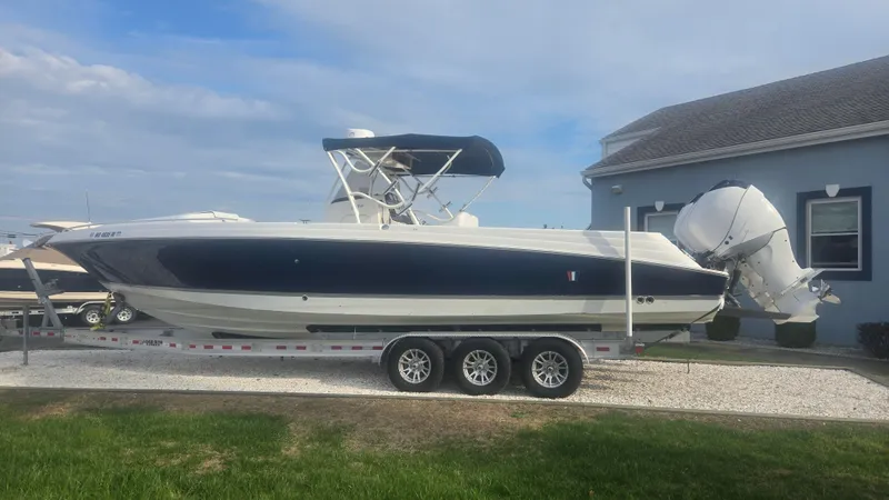 Slide: The Image of 2006 Wellcraft 352 Sport Scarab boat on trailer, parked beside a house. - 21