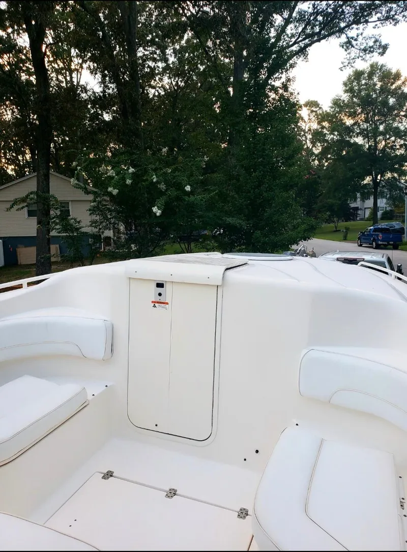Slide: The Image of 2006 Wellcraft 352 Sport boat interior with white seating, surrounded by trees. - 6