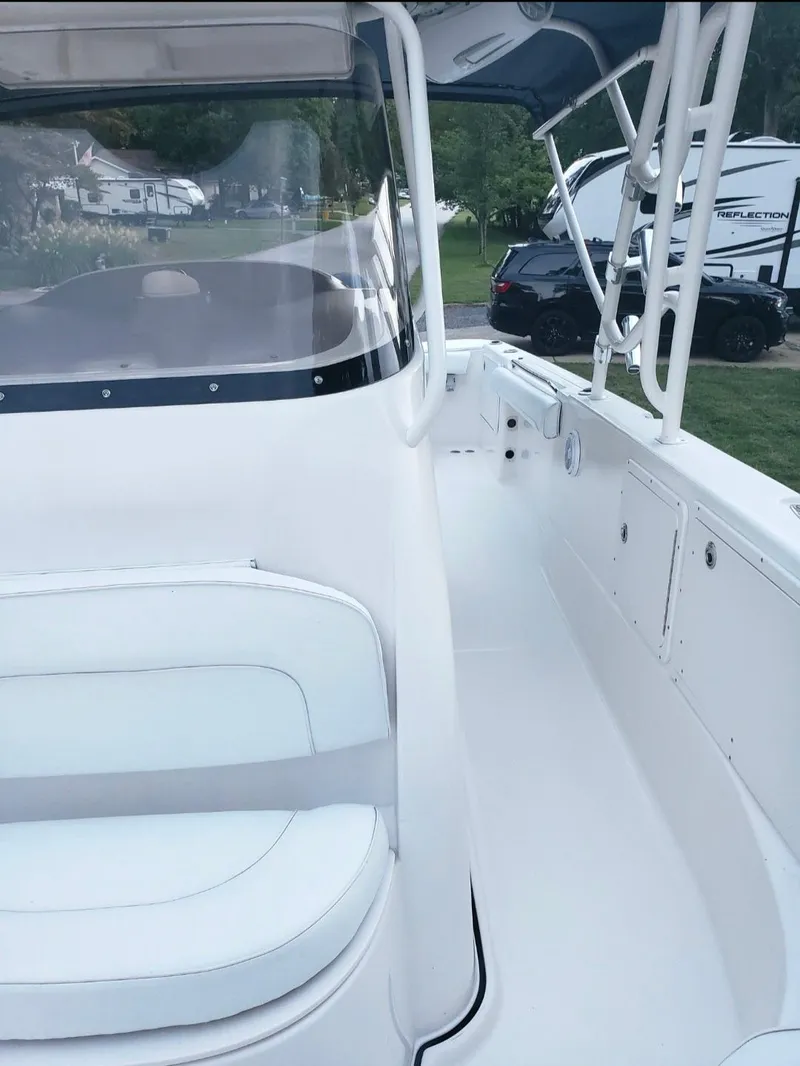 Slide: The Image of 2006 Wellcraft 352 Sport boat, white interior, docked near RVs and vehicles. - 7