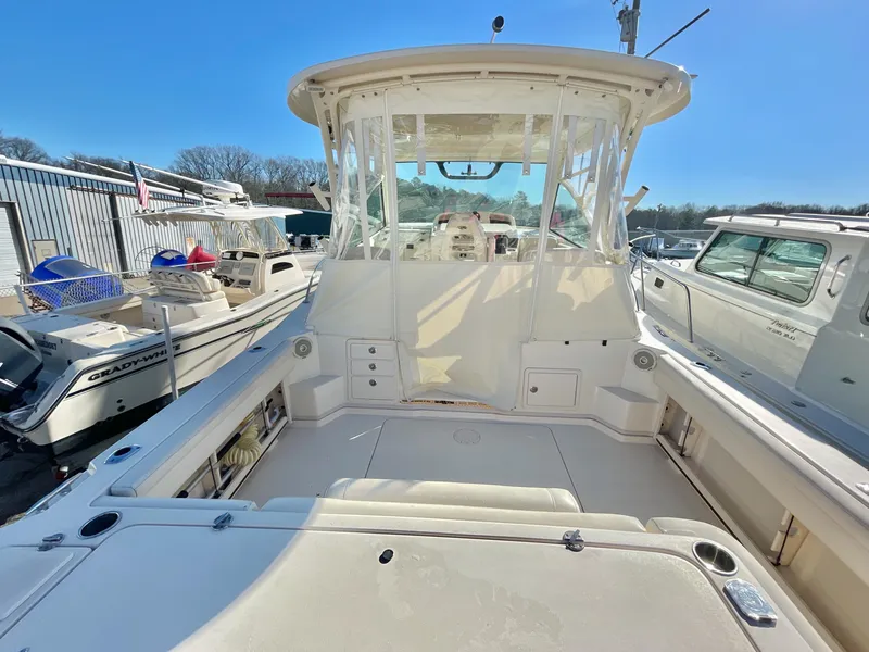 Slide: The Image of 2015 Grady-White Express 330 boat, spacious deck, clear skies, marina setting. - 12
