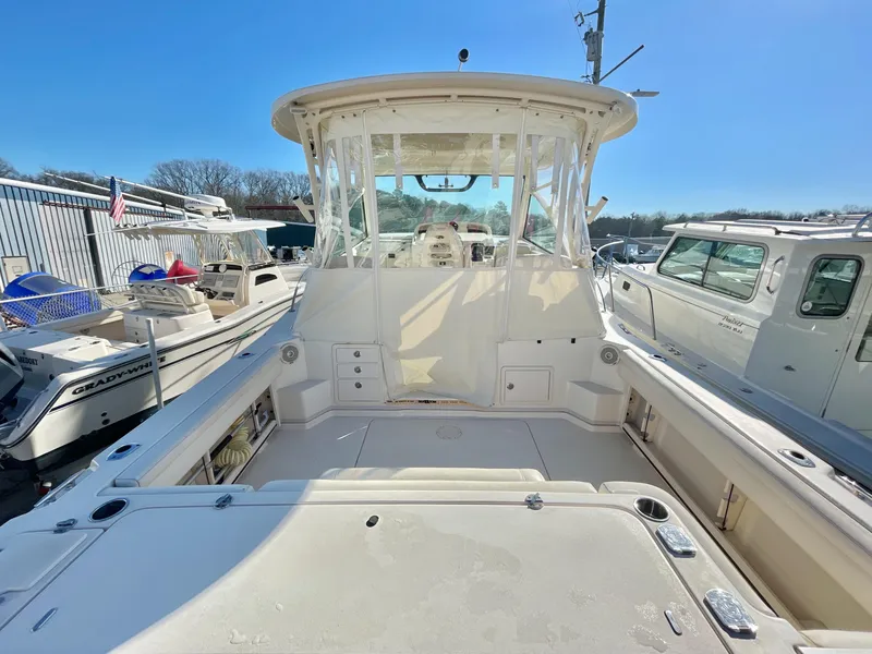 Slide: The Image of 2015 Grady-White Express 330 boat, spacious deck, clear skies, marina setting. - 13