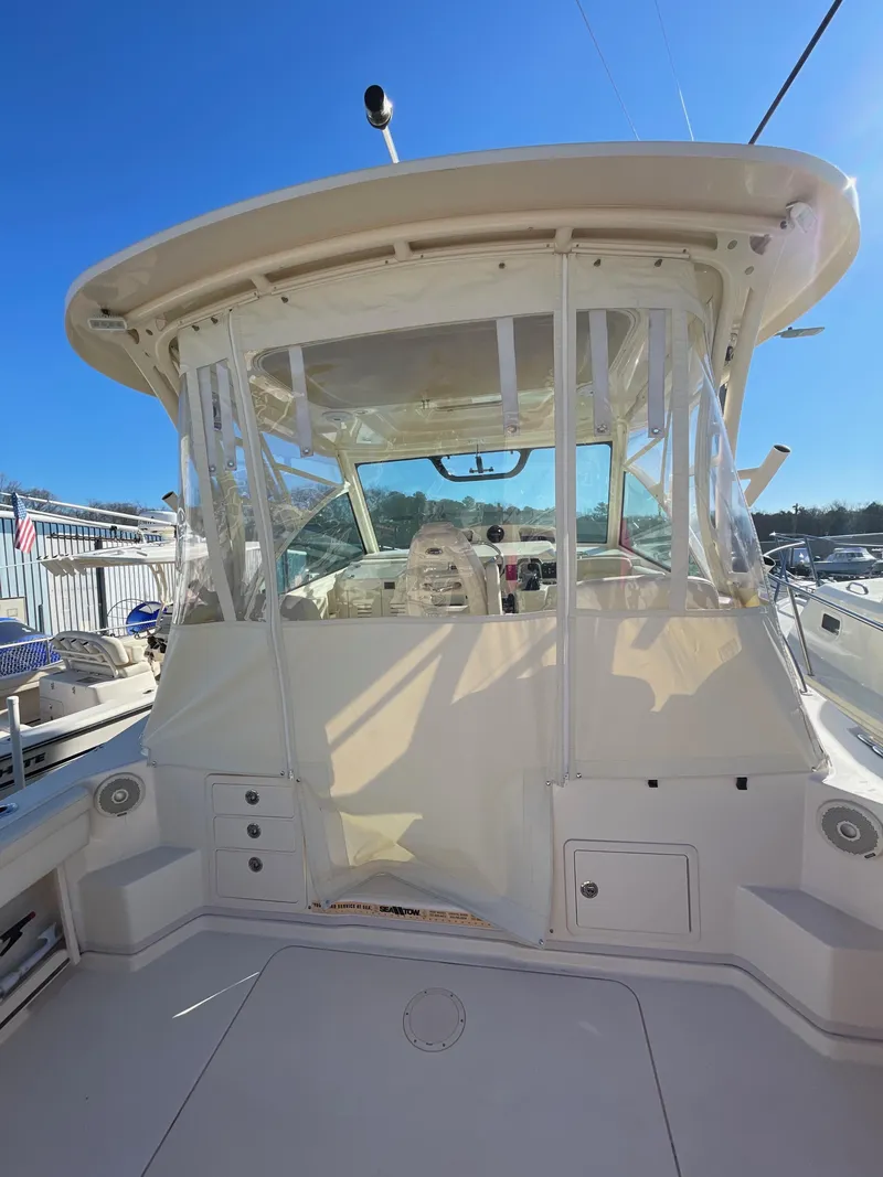 Slide: The Image of 2015 Grady-White Express 330 boat cockpit with clear enclosure under sunny sky. - 18