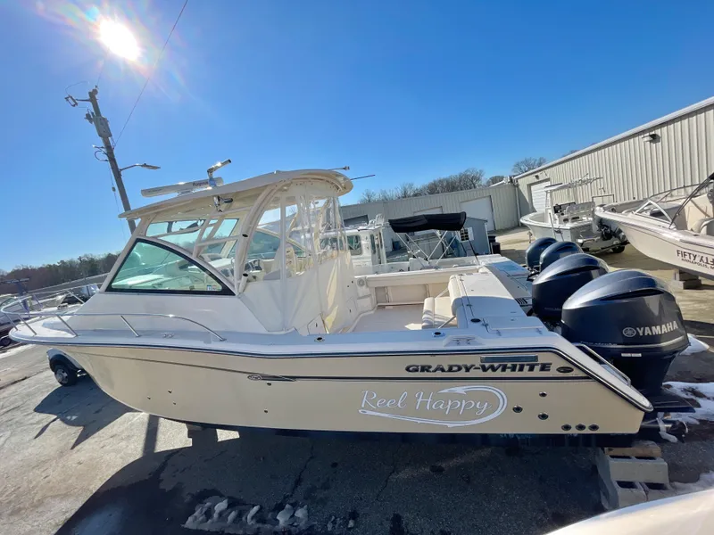 Slide: The Image of 2015 Grady-White Express 330 boat with Yamaha engines, docked under clear blue sky. - 2