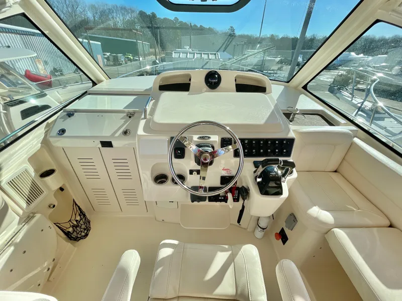 Slide: The Image of 2015 Grady-White Express 330 helm with steering wheel and control panel in bright sunlight. - 22