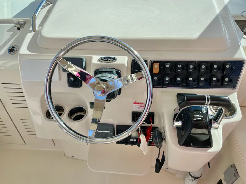 Slide: The Image of 2015 Grady-White Express 330 helm with steering wheel and control panel. - 23